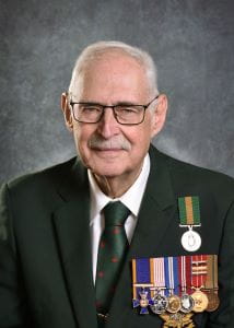Lieutenant-Colonel (Ret’d) Lyle Johnson, O.M.M., C.D. with the Saskatchewan Volunteer Medal among numerous others on his dark suit jacket.